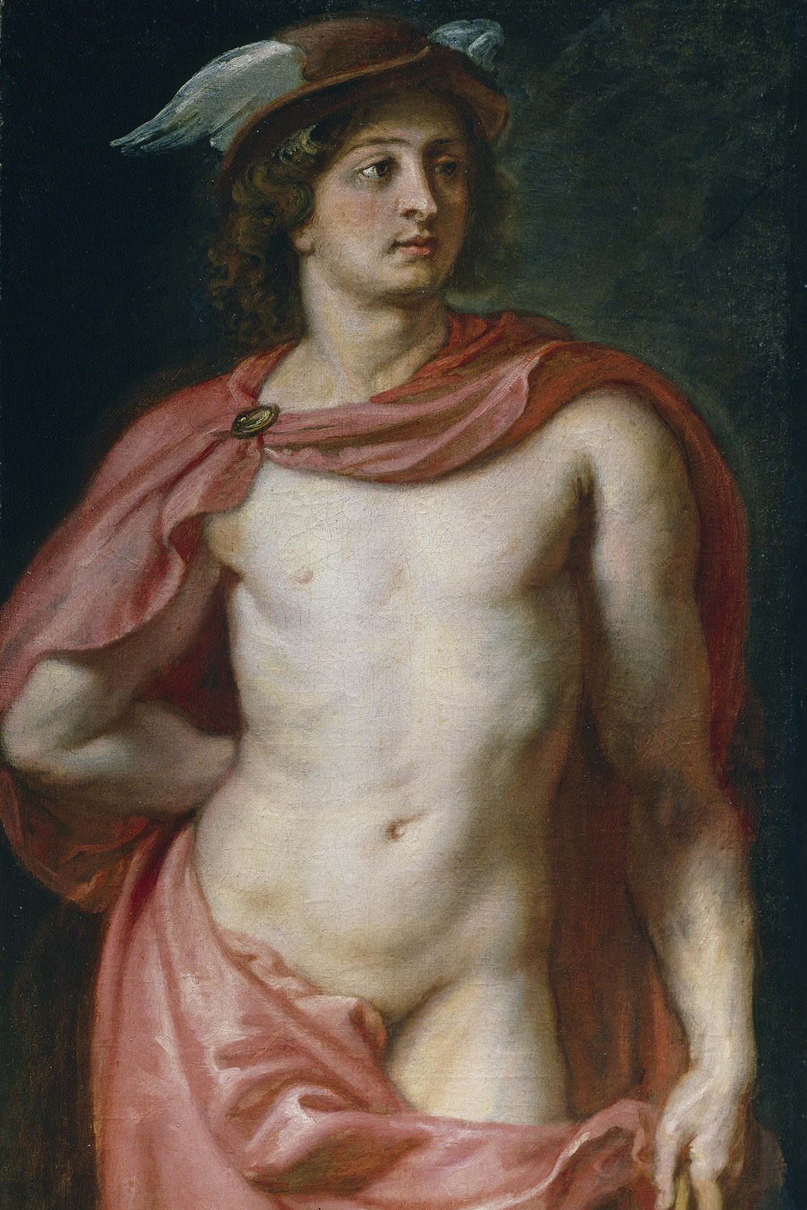 The young Hermes, unbearded and long-haired, wearing the winged traveller's hat (petasos) with its pale feathers spread at either side. A coral-rose mantle is clasped at one shoulder with a gold brooch and falls across his bare torso; he stands against a dark ground, his head turned to gaze aside.
